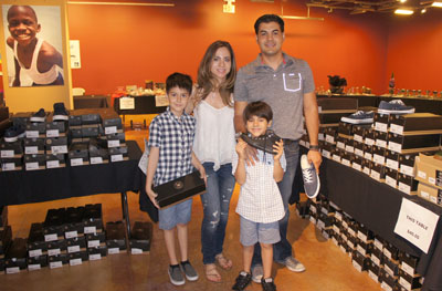 Taking advantage of the great footwear prices at the Global Family Philanthropy Pop-Up Shop last month at the Scottsdale Waterfront are the Castro family from Casa Grande, clockwise from left: Ricky, 9; Myriam; Ricardo; and Danny, 7. All proceeds benefited the Sunnyslope Youth Center (photo by Teri Carnicelli).
