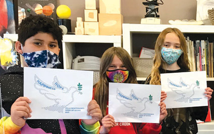 Villa Montessori School is shifting its annual gala night to an online format this year. The public can bid on items and buy raffle tickets online. Students pictured here are holding the logo of the auction, designed by student Stella TenBrook (photo by Athena Moskoyes).