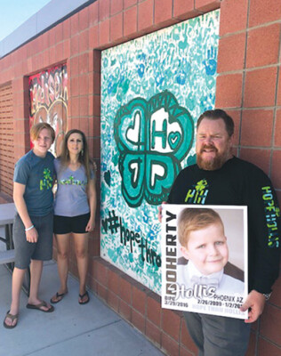 Rhett Doherty and his mother, Shawnee Doherty, and his father Shane Doherty pose near a mural that students at Madison Meadows Middle School painted to honor the memory of Rhett’s brother, Hollis (photo courtesy of the Madison Elementary School District).