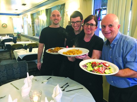 Dinner at GreekTown is a family affair. From left sons Grigori and Dimitri Vassiliou, mom Anastasia and dad, George Vassiliou. They’re serving souvlaki, left, shrimp in lemon sauce and classic Greek salad (photo by Marjorie Rice). 