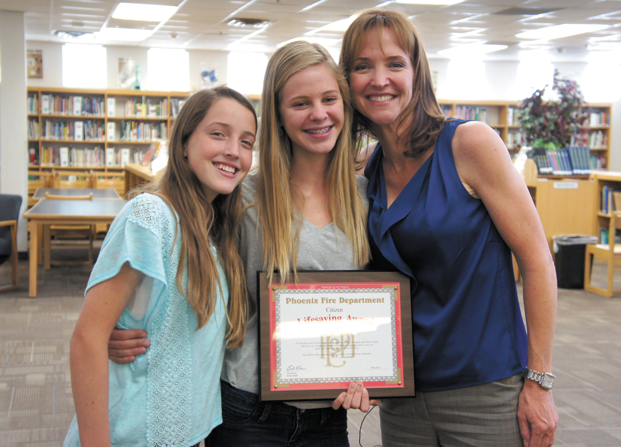 Brooke Gerlach, center, displays the plaque presented to her by the Phoenix Fire Department for potentially saving her own life as well as the lives of Susan Mulligan, right, and Susan’s daughter, Claire Pischko, left (photo by Teri Carnicelli).