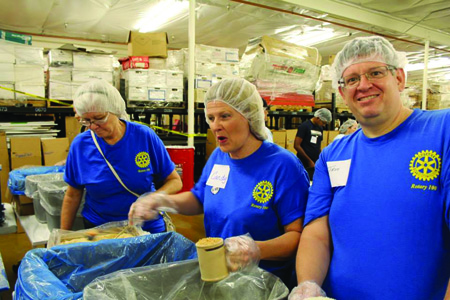 Phoenix Rotary 100 members, from left, Nancy Teff, Candy Carroll and Troy McNemar pack up bags of food that will be shipped to hungry families around the globe during its “Mega Pack” event for nonprofit Feed My Starving Children (submitted photo).