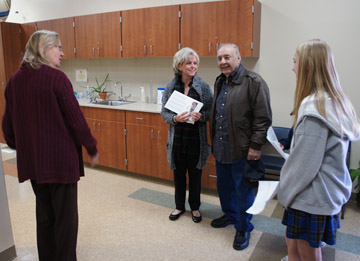 St. Francis Xavier School nurse Marie Heggestad, left, happily shows off her new nursing office to school visitors, Betsy Williams and Louis Reinhart, as well as SFX student Ana Alvarez, who was leading the woman and her father-in-law on a tour of the new school wing during Grandparents Day on Dec. 6 (photo by Teri Carnicelli).