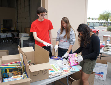 Sorting and labeling children’s books donated to the Washington Elementary School District are members of the Sunnyslope High School Key Club, from left: Scott Kottmer, Ally Marshall and Denisse Roman (photo by Teri Carnicelli).