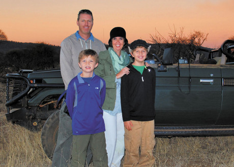 Enjoying a spectacular sunset at the Madikwe Game Reserve in South Africa are the members of the globe-trotting Simmons family, clockwise from top left: dad Jeremy, mom Carrie, and sons Nathan and Seamus (photo courtesy of Travel With Kids).