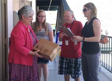 Lesli Stern, program manager at Valleylife (far right), and Valleylife member Chris deliver office supplies, printer ink and copy paper to Cathie Hanna McClellan, director of the Early Care and Education Center at Desert Christian Fellowship, and her administrative assistant, Amy Prigmore (submitted photo).