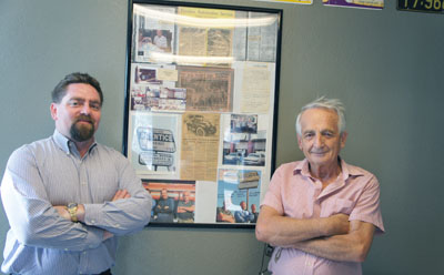 Dan Kingston, left, recently purchased Prentice Garage from Mitch Dehelean, right, who owned the auto repair shop for more than 20 years. On the wall of the revamped lobby is a framed history of the shop, which first opened in 1932 and is the only auto repair and service business in Phoenix to have operated continuously for more than 80 years (photo by Teri Carnicelli).