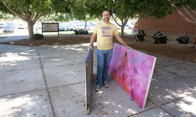 Phoenix Center for the Arts Director Joseph Benesh prepares to load two large mural panels into a truck, to be delivered to an affordable housing community in downtown Phoenix for formerly homeless and low-income individuals. The donation is part of a recent agreement between PCA and Arizona Housing Inc. (photo courtesy of Phoenix Center for the Arts).