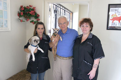 Gabor Vajda, center, owner of the new ServePets multi-service pet facility, says that your canine companions will be treated like family there. Pictured with him are groomer Jennifer Stiner, left, and her Shih Tzu, Weedo; groomer Tina Hemby; and Prissy, one of the two staff dogs at the North Central News (photo by Teri Carnicelli).