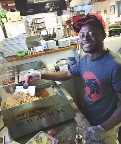 Rodrigue Wasanj, a 20­year­old refugee from the Democratic Republic of Congo who immigrated to Arizona in 2011, works as a cook at The Refuge Café, a social enterprise of Catholic Charities (photo courtesy of The Refuge).