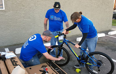 Assembling a bike to donate to Tumbleweed’s Young Adult program are members of The Mission Continues 2nd Platoon Phoenix, from left: Ken Arneson, Robert Kestle and Michelle Ray (photo courtesy of The Mission Continues).
