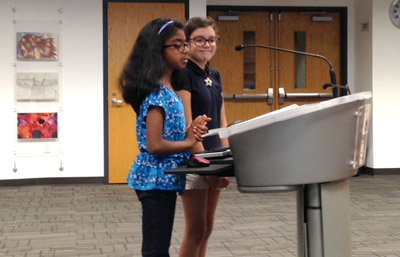 Amutha Rajasundaram, left, and Sally Fielder, both fourth graders at Madison Heights, speak to the Madison Elementary District Governing Board at its April 19 meeting about the health benefits of being active at recess as well as the opportunity to socialize with friends, which they can’t do in the classroom without risking getting in trouble (photo by Teri Carnicelli).