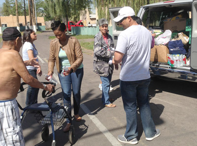 Volunteers with Phoenix Rescue Mission’s Hope Coach hand out heat-relief items, including bottled water, to members of the homeless community during the summertime (photo by Cliff Danley).