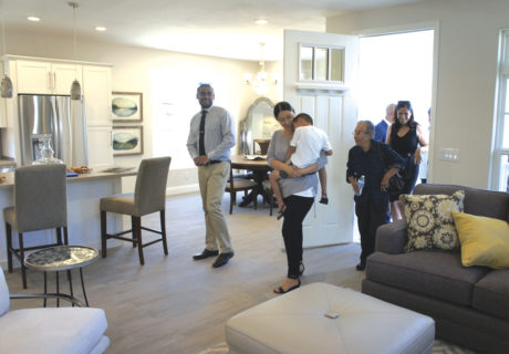 Zahid Ali enters his brand new home in Sunnyslope on July 26 followed by wife, Stephanie (with son Noé), and various guests and dignitaries. The home, manufactured by Champion Home Builders in Chandler, was donated to the Ali family by Rebuilding Together Valley of the Sun and NextGen Home. It was fully furnished thanks to Bassett Furniture (photo by Teri Carnicelli).